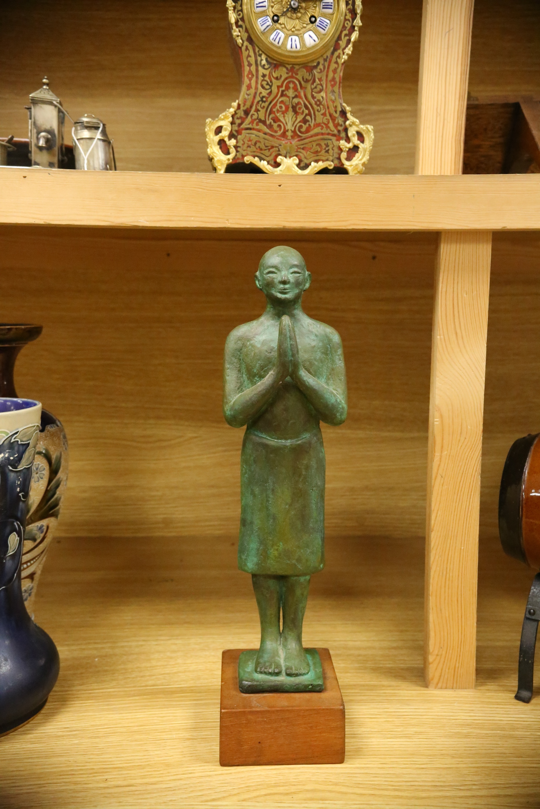 A figural bronze of an Oriental gentleman in prayer, height 42cm including stand. Condition - good